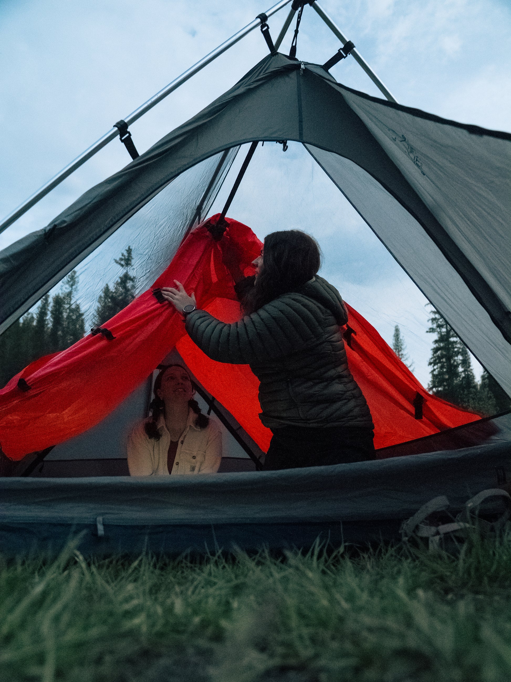 two people closing the internal rainfly inside a stargazing tent